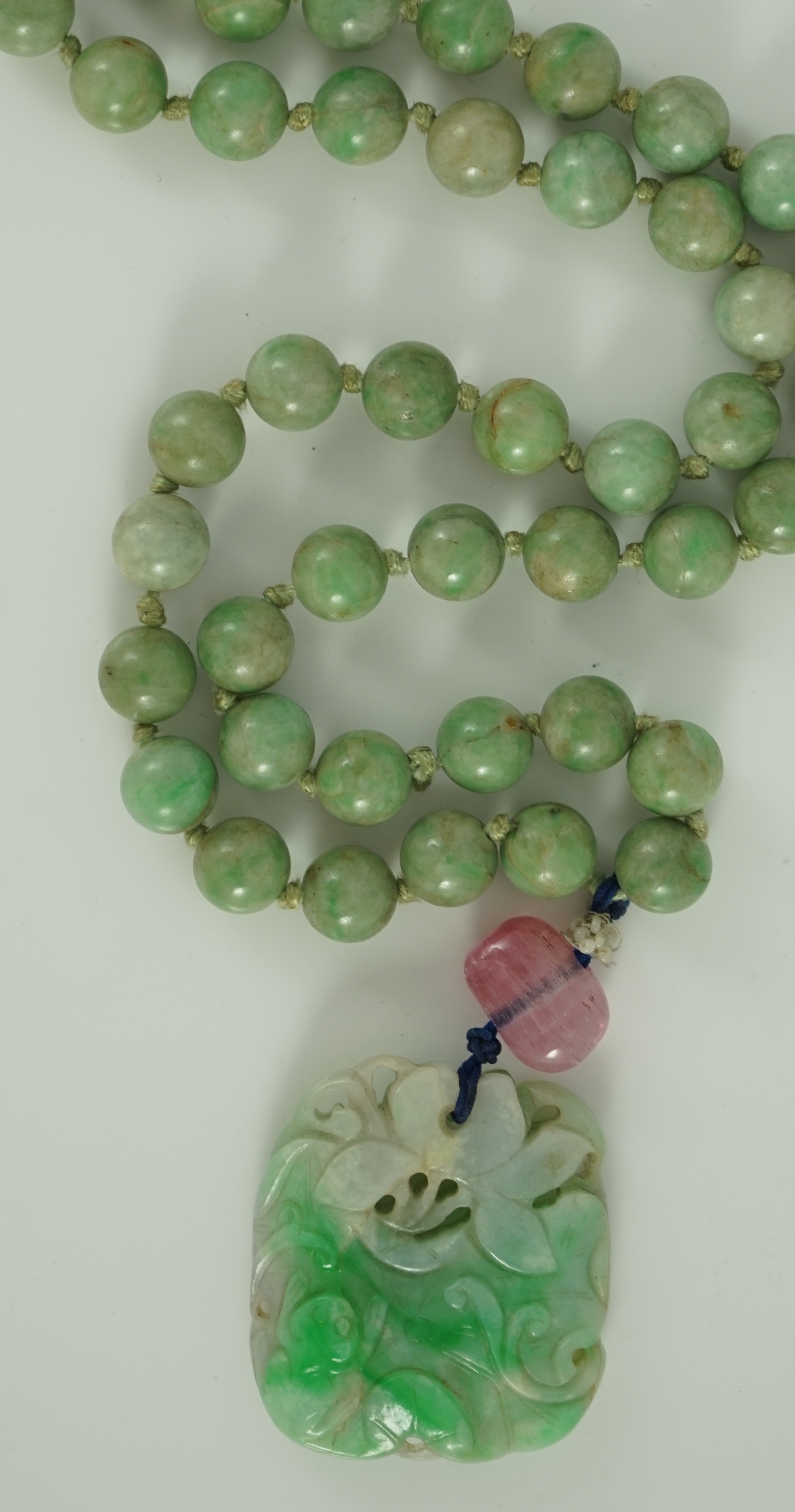 A Chinese jadeite pendant and jadeite beads, 19th century, Pendant 3.9 cm, total drop 68 cm